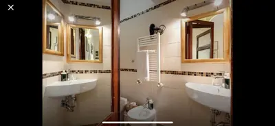 a bathroom with two sinks and two mirrors at Center Rome Coliseum in Rome