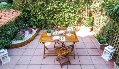 a table and chairs in a garden with plants at Casa Sofia - beauty apartment close Vatican Museum in Rome
