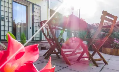a wooden rocking chair on a patio with a flower at Casa Sofia - beauty apartment close Vatican Museum in Rome