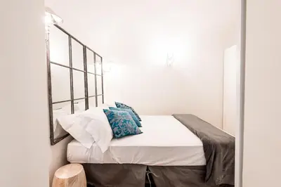 a bed with white sheets and blue pillows in a room at Casa Prati Michelangelo in Rome