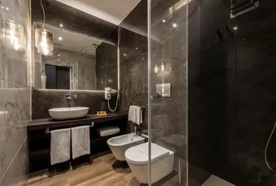 a bathroom with a toilet and a sink and a mirror at Growel Exclusive Suites San Pietro in Rome