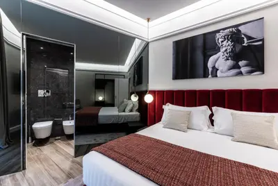 a hotel room with a bed and a bathroom at Growel Exclusive Suites San Pietro in Rome