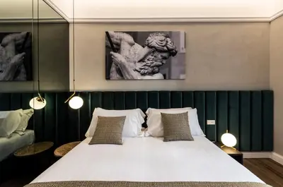 a bedroom with a large white bed with two pillows at Growel Exclusive Suites San Pietro in Rome