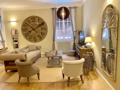 a living room with a couch and chairs and a clock at Frattina Luxury House in Rome
