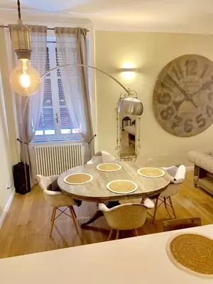 a dining room with a table and chairs and a clock at Frattina Luxury House in Rome