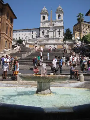a group of people standing around a fountain in front of a building at Frattina Luxury House in Rome