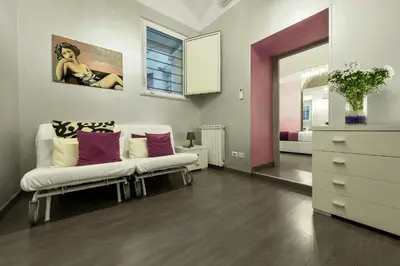 a living room with a white couch and a dresser at Casa Calpurnia in Rome