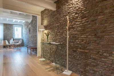 a brick wall in a room with a table and chairs at Campo De' Fiori Apartment - Charme Holidays in Rome