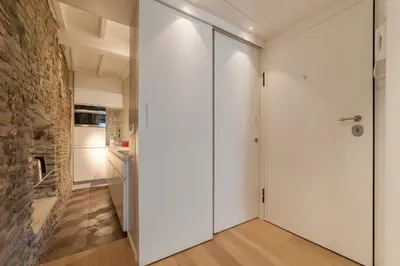 a hallway with white sliding doors and a stone wall at Campo De' Fiori Apartment - Charme Holidays in Rome