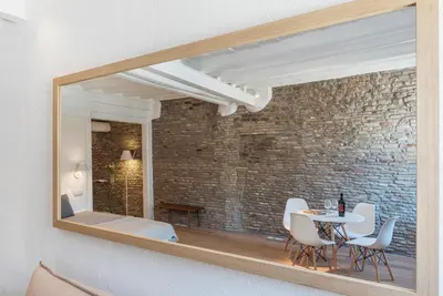 a mirror reflecting a dining room with a table and chairs at Campo De' Fiori Apartment - Charme Holidays in Rome