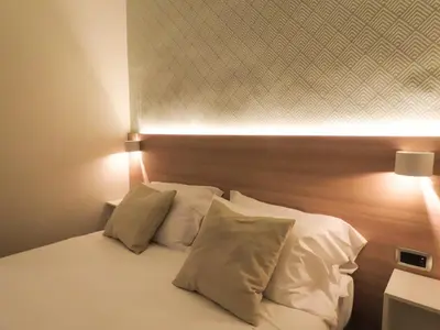 a bedroom with a bed with white sheets and pillows at My Maison 109 Guest House in Rome