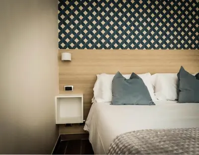 a bed with blue and white pillows in a room at My Maison 109 Guest House in Rome