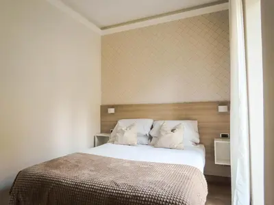 a bedroom with a large bed with white sheets at My Maison 109 Guest House in Rome