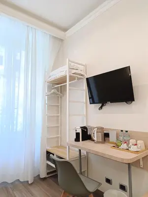 a room with a desk with a television on a wall at My Maison 109 Guest House in Rome