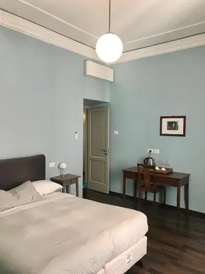 a bedroom with a large bed and a desk at B&B Santi Quattro Al Colosseo in Rome