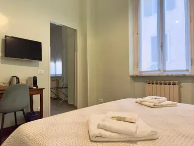 a bedroom with two towels on a bed with a desk at B&B Santi Quattro Al Colosseo in Rome