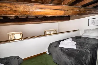 a bedroom with a bed and two windows at Appartamento via dei Baullari in Rome
