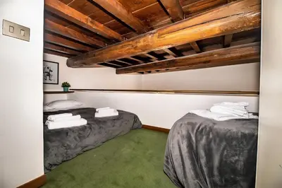 two beds in a room with wooden ceilings at Appartamento via dei Baullari in Rome