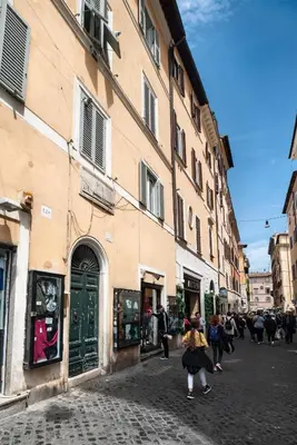 a group of people walking down a street next to a building at Appartamento via dei Baullari in Rome