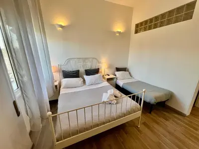 a small bedroom with two beds and a crib at Enjoy Vatican in Rome