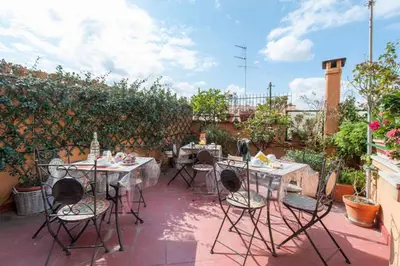 a patio with tables and chairs on a patio at Casa Via Cesena in Rome