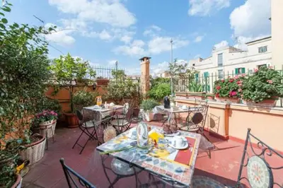 a patio with tables and chairs on a balcony at Casa Via Cesena in Rome