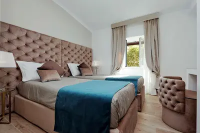a bedroom with two beds and a couch and a window at Relais Aquarium in Rome