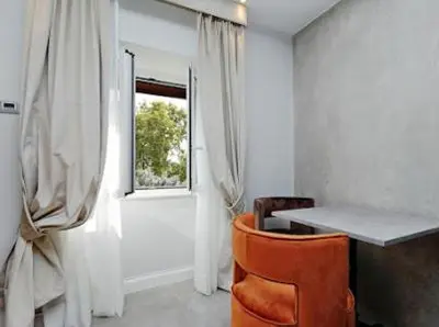 a room with a desk and a chair and a window at Relais Aquarium in Rome