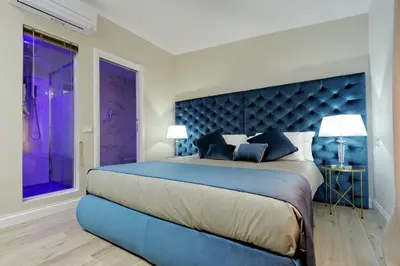 a bedroom with a large bed with a blue headboard at Relais Aquarium in Rome
