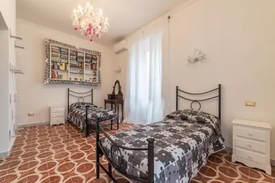 a bedroom with two beds and a chandelier at GuestHost - Piramide & Testaccio Design Flat in Rome