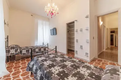 a bedroom with a bed and a couch and a chandelier at GuestHost - Piramide & Testaccio Design Flat in Rome