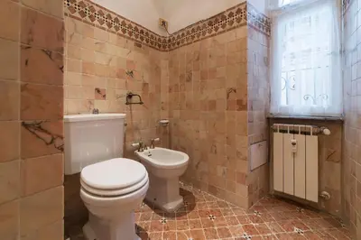a bathroom with a toilet and a sink and a window at GuestHost - Piramide & Testaccio Design Flat in Rome