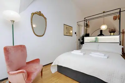 a bedroom with a bed and a chair and a mirror at Restart Accommodations Celimontana in Rome