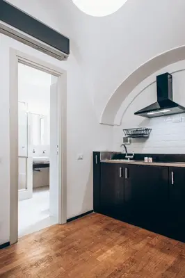 a kitchen with black cabinets and a sink at Restart Accommodations Celimontana in Rome
