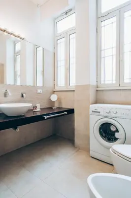 a bathroom with a washing machine and a sink at Restart Accommodations Celimontana in Rome