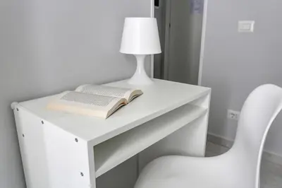 a white desk with a book and a lamp and a chair at Voyager House Termini - Home and More in Rome