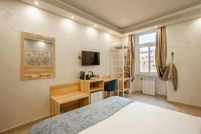 a bedroom with a bed and a desk and a television at Drago D'Oro GUESTHOUSE - accross from metro Vittorio Emanuele in Rome