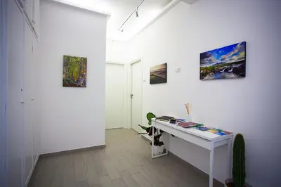 a white room with a desk and paintings on the wall at Elements Guest House Roma in Rome