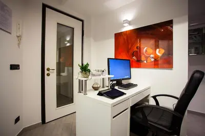 a desk with a computer on it with a chair at Elements Guest House Roma in Rome