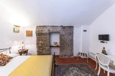 a bedroom with a bed and a brick wall at Rifugio degli Artisti B&B in Rome