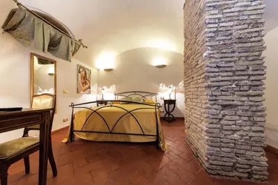 a bedroom with a bed and a brick wall at Rifugio degli Artisti B&B in Rome