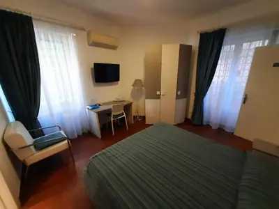 a bedroom with a bed and a desk with a television at B&B Five in Rome