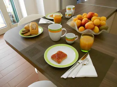 a table topped with plates of breakfast foods and orange juice at B&B Five in Rome