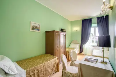 a bedroom with two beds and a desk and a table at Residenza Dei Principi in Rome
