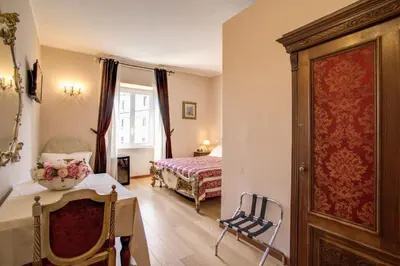 a bedroom with a bed and a table and a chair at Residenza Dei Principi in Rome