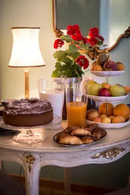 a table with a cake and a plate of food at Residenza Dei Principi in Rome