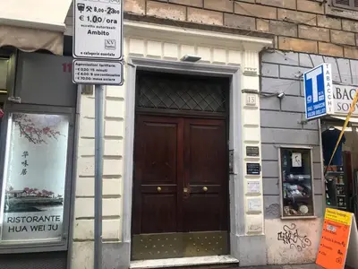 a large wooden door on a building with street signs at Iris Guest House in Rome