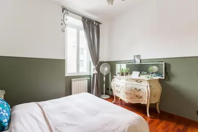 a bedroom with a bed and a dresser with a mirror at New Suite Amèlie in Rome
