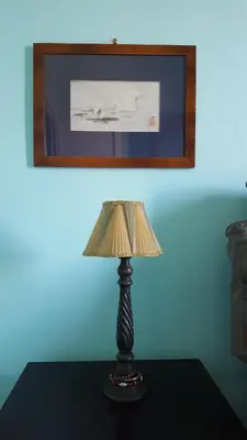 a lamp sitting on a table in front of a picture at Casa di Walter al Pigneto in Rome