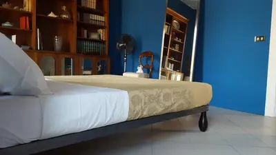 a bed in a room with a blue wall at Casa di Walter al Pigneto in Rome